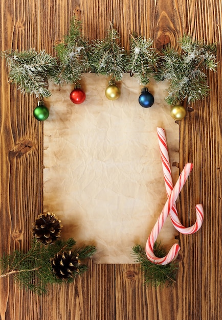 Foto weihnachtsschmuck auf dem alten blatt papier auf holzuntergrund, platz für text