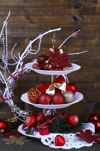 Weihnachtsschmuck auf Dessertständer, auf Holzuntergrund