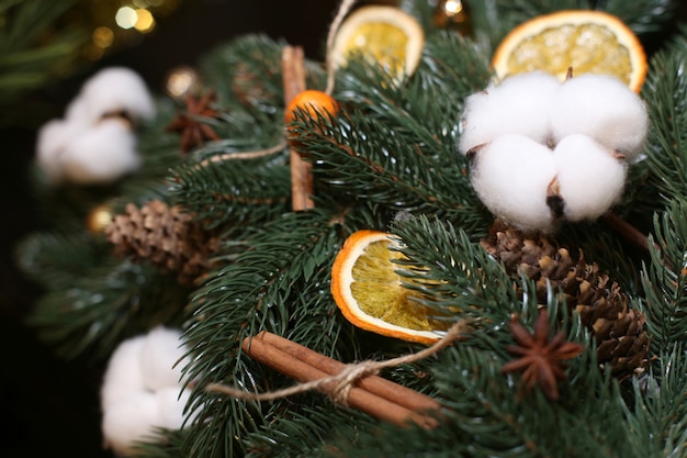 Weihnachtsschmuck aus künstlichem Weihnachtsbaum, Wattebäusche, Zapfen, Orangenscheiben.