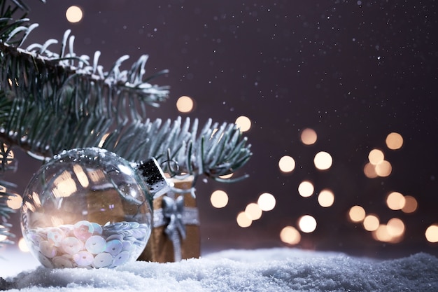 Weihnachtsschmuck-Banner. Verschneiter Tannenzweig mit Weihnachtsbeleuchtung Bokeh in der Nacht. Panorama-Hintergrund. Weihnachtskomposition. Neujahr 2020 Feiertage