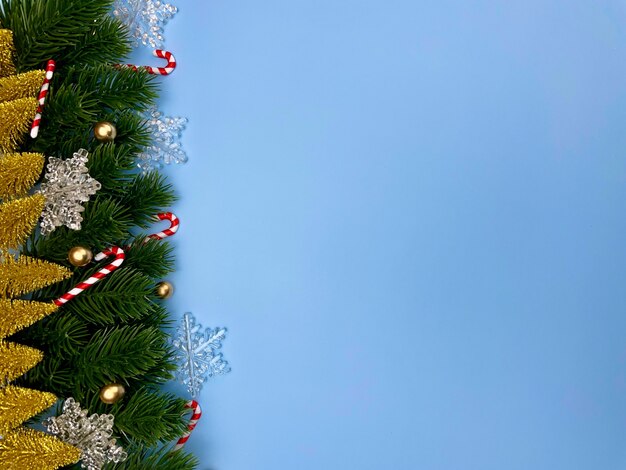 Weihnachtsschmuck Kiefer lässt goldene Kugeln Schneeflocken auf blauem Hintergrund