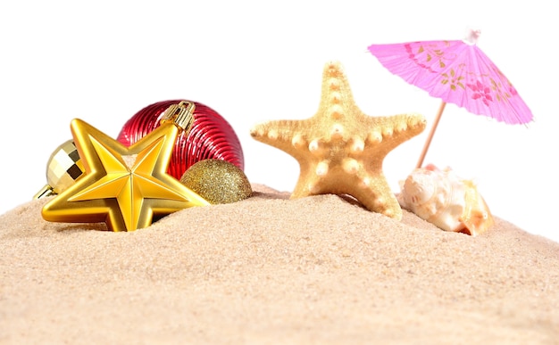 Weihnachtsschmuck Muscheln und Seesterne auf einem Strandsand auf weißem Hintergrund