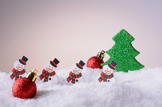 Weihnachtsschmuck Schneemänner, Weihnachtsbaum und rote Kugeln auf Schnee