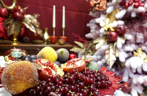 Weihnachtsschmuck und bunte Beeren mit Kerzen