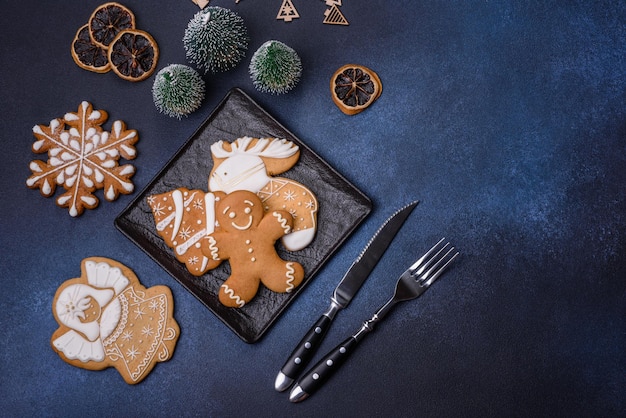 Weihnachtsschmuck und Lebkuchen auf einem dunklen Betontisch Bereiten Sie sich auf die Feier vor