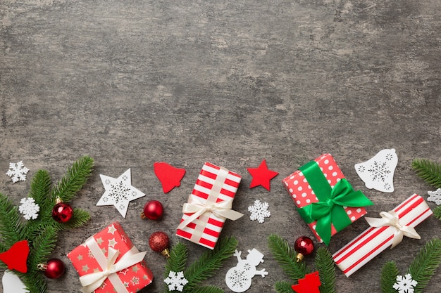 Weihnachtsschmuck und Tannenzweig und Geschenkbox auf dunklem Tisch. Draufsichtrahmen mit kopierraum