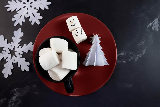 Weihnachtsschneemann-Schneeflocken-Origami-Baum und Marshmallows in der Tasse