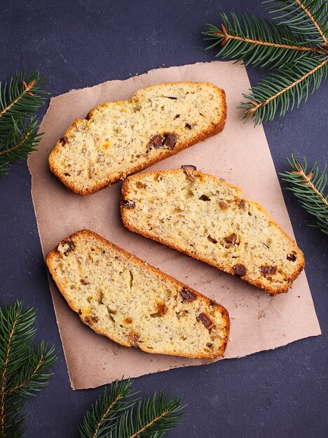 Weihnachtsselbst gemachter Kuchen schnitt in Stücke auf einem schwarzen Hintergrund