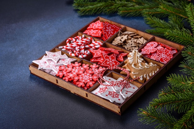 Weihnachtsspielzeug in Weiß und Rot in einer Holzbox vor einem dunklen Betonhintergrund