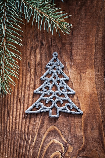 Weihnachtsspielzeug Tannenbaum mit Tannenzweigen auf altem Holzbrett aus nächster Nähe