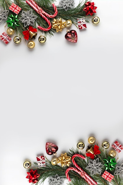 Weihnachtsspielzeug und -dekorationen mit Tannenzweig auf weißem Hintergrund mit Kopienraum