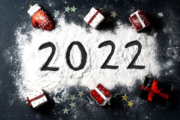 Foto weihnachtsspielzeug vorhanden geformt und geschrieben 2022 auf schwarzem hintergrund