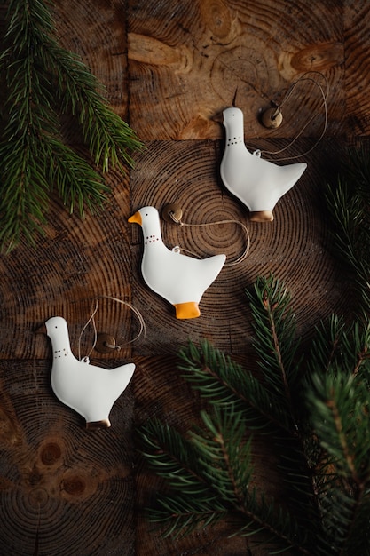 Foto weihnachtsspielzeugvögel auf holztisch mit tannenzweigen