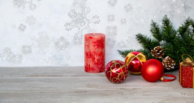 Weihnachtsstimmung Neujahrshintergrund Weihnachtstannenzweige rote Weihnachtskugeln, eine Kerze und Geschenkboxen auf einem Hintergrund von Raureifmustern mit Kopierbereich Urlaubsatmosphäre