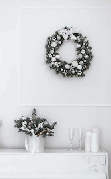 Foto weihnachtsstrauß aus fichte und baumwolle in einem weißen interieur vor dem hintergrund eines weißen klaviers