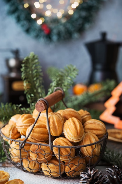 Weihnachtssüßigkeiten Kekse Nüsse mit Kondensmilch auf dem festlichen Tisch, Weihnachtsdekorationen, selektiver Fokus