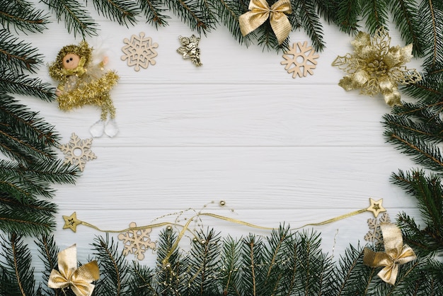 Weihnachtstannenbaum mit Dekoration und Glitzern auf hölzernem Hintergrund. Weihnachtshintergrund auf dem weißen hölzernen Schreibtisch