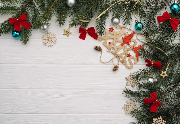 Weihnachtstannenbaum mit Dekoration und Glitzern auf hölzernem Hintergrund.