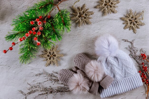 Weihnachtstannenbaum mit roten Beeren, Schneeflocken und Handschuhen mit Hut