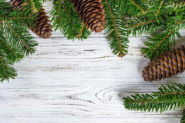 Weihnachtstannenbaum mit Tannenzapfen auf einem Holzbrett