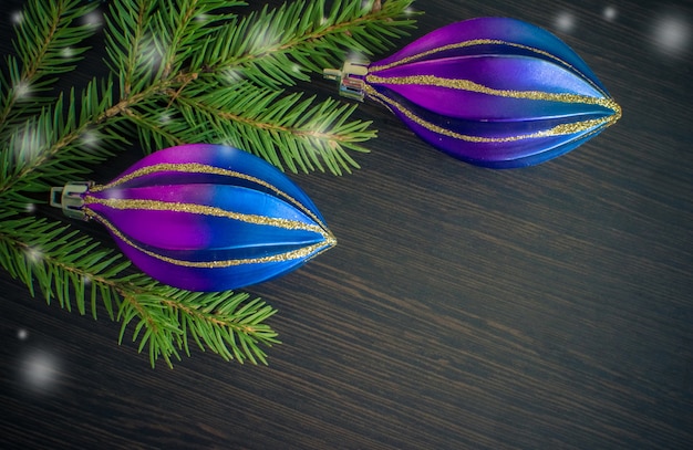 Weihnachtstannenbaum und purpurrote Dekoration auf hölzernem Brett.