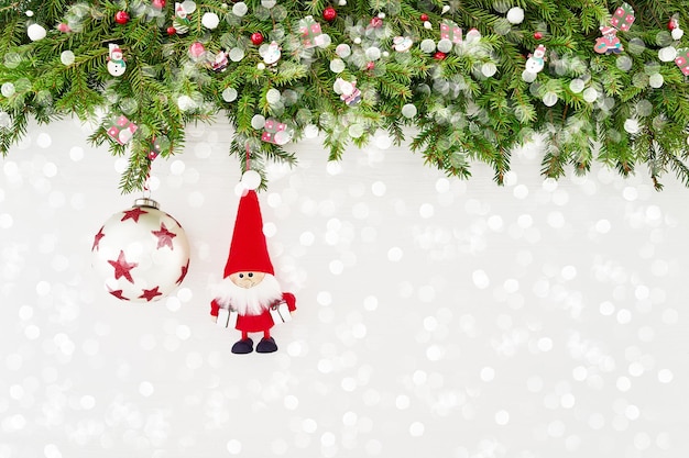 Weihnachtstannenzweig mit Sankt und Dekoration auf Draufsicht des weißen hölzernen Hintergrundkopienraums
