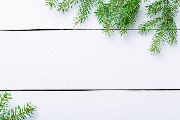 Weihnachtstannenzweige auf weißem rustikalem Holzbrett mit Kopienraum