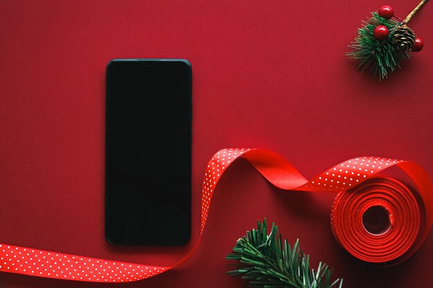 Weihnachtstelefon-App und Feiertagsnachrichtenkonzept-Smartphone mit leerem schwarzem Bildschirm und Weihnachtsdekor...