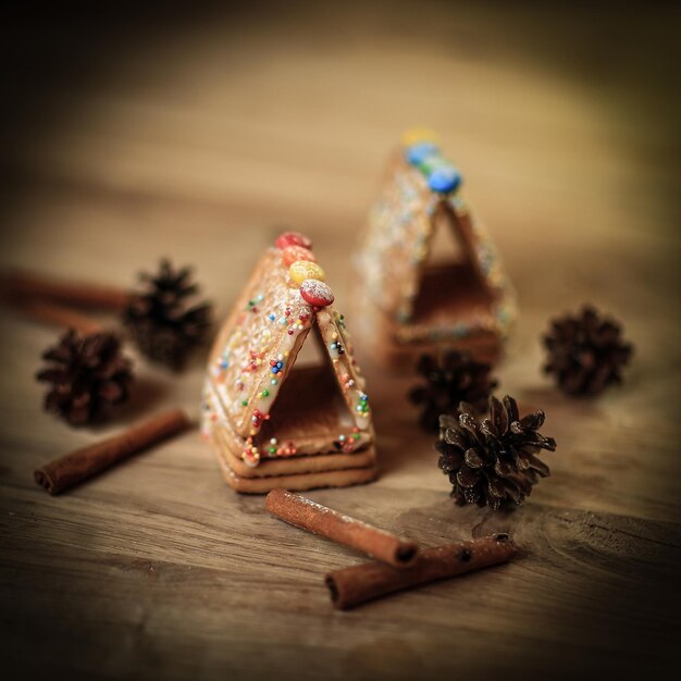 Weihnachtstisch Zimtstangenkekse und Tannenzapfen auf Holz