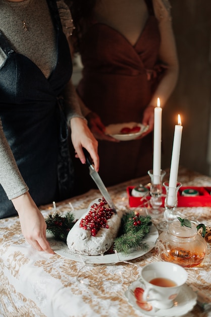 Weihnachtstischnahaufnahmemädchen, die weihnachtskuchen schneiden