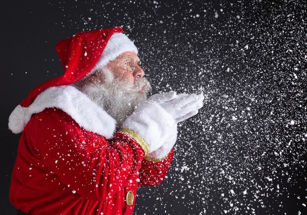 Weihnachtstraditionen. Sankt weht Schneeflocken.