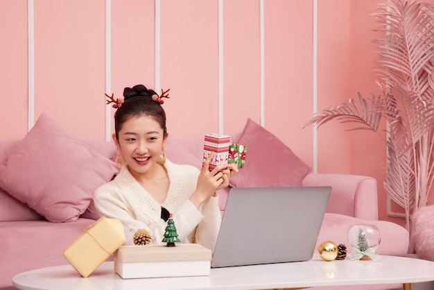 Weihnachtsverkaufskonzept. Schönheit asiatische Frau, die Produktweihnachts-Shopping online zeigt