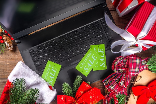 Weihnachtsverkaufskonzept. Schwarzer Freitag, grüner oder Cyber Montag Hintergrund mit Laptop, Tablet, Weihnachtsdekor und Geschenkboxen,