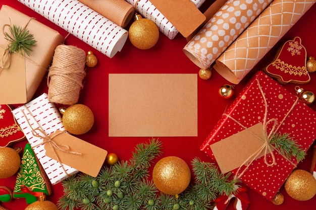 Weihnachtsvorbereitungskonzept mit Geschenkpapier, Geschenkboxen auf rotem Hintergrund mit Kopienraum