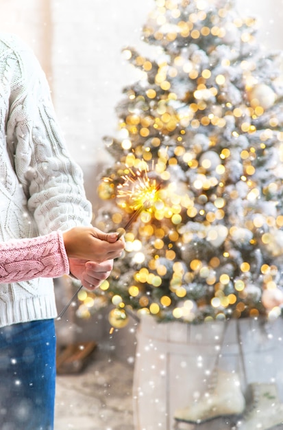 Weihnachtswunderkerzen in den Händen eines Mannes und einer Frau. Urlaub. Selektiver Fokus. Personen.