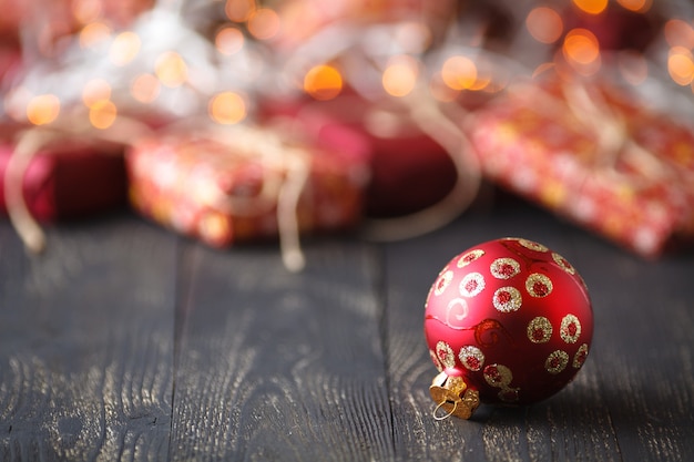 Weihnachtszeit. ein Weihnachtsball vor ein paar Geschenken auf dem Tisch