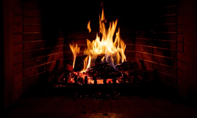 Weihnachtszeit gemütlicher Kamin Holzscheite brennen Feuerziegel Hintergrund Entspannung und warmes Zuhause