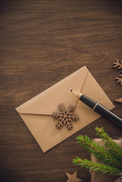 Weihnachtszeit Leerer Umschlag mit Luxusstift auf dem rustikalen Tisch