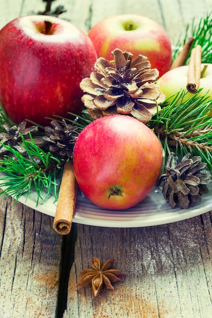 Weihnachtszusammensetzung auf einer Servierplatte, Äpfel, Baumaste