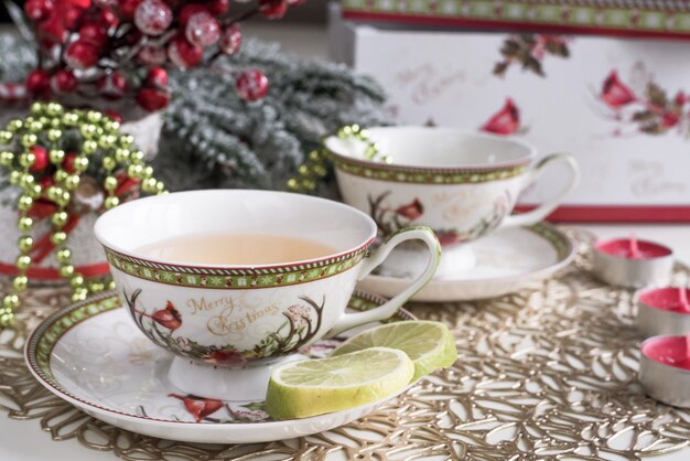Weihnachtszusammensetzung mit Blumen und weißen Teeschalen