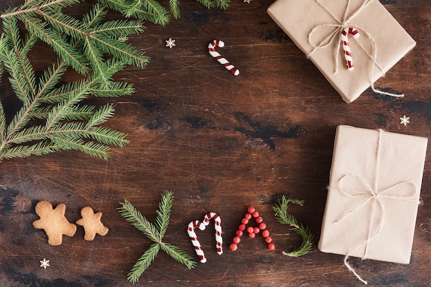 Weihnachtszusammensetzung mit Geschenk- und Lebkuchenmann auf hölzerner Dunkelheit.