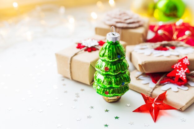 Weihnachtszusammensetzung mit grünem dekorativem Tannenbaum, Geschenken und Dekorationen