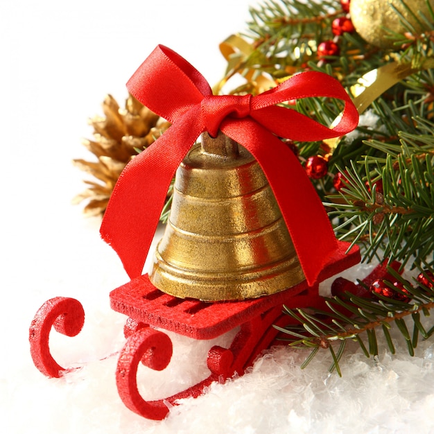 Weihnachtszusammensetzung mit Pferdeschlitten und goldener Glocke über Weiß