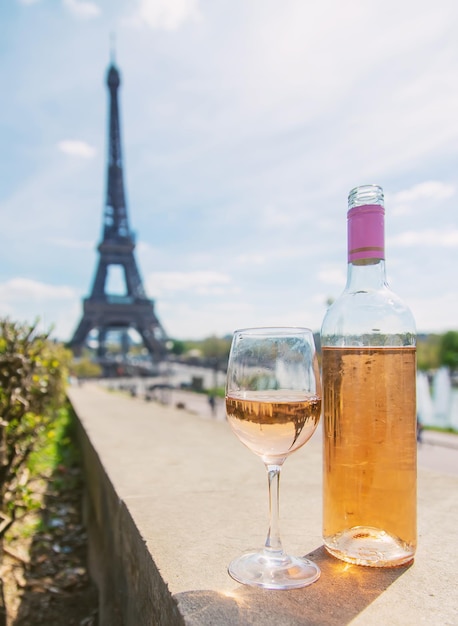 Wein in einem Glas in der Nähe des Eiffelturms Selektiver Fokus