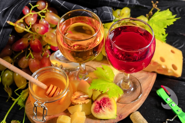 Wein mit Zweigen der weißen Trauben. Auf einem Holztisch.