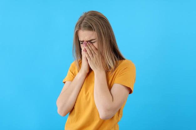 Weinendes Mädchen im T-Shirt auf blauem Hintergrund