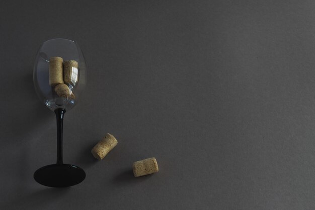 Weinglas mit Weinkorken auf dunklem Hintergrund mit Platz für Text. Verwendung in Form von Werbung, Postern, Prospekten, Visitenkarten von Lebensmittelbetrieben, Restaurants.