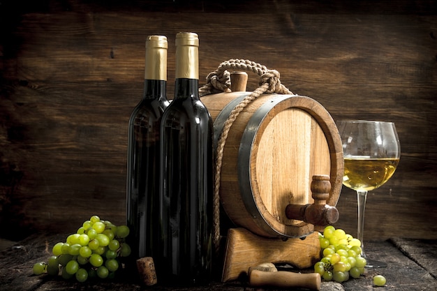 Weinhintergrund. Ein Fass Weißwein mit Zweigen grüner Trauben.