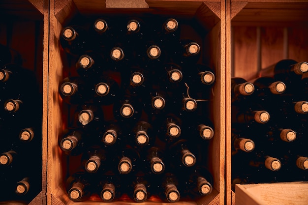 Weinkeller oder Lagerraum mit Glasflaschen alkoholischer Getränke in Holzkisten c