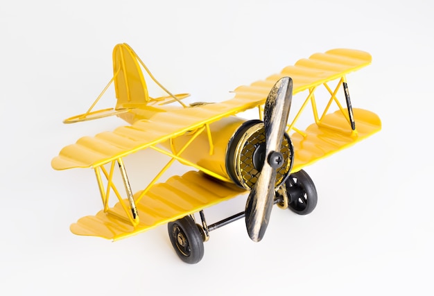 Weinlese-Gelb-Metallspielzeugflugzeug auf weißem Hintergrund